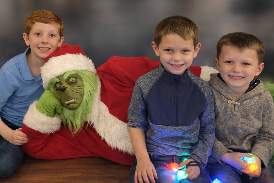 Santa Dave as the Grinch posing with three children